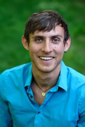 Dan Entmacher, smiling, in a blue shirt outdoors